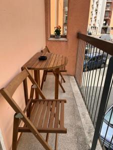 a wooden table and a chair on a balcony at Dimora Stadio Biella in Biella