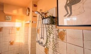 a shower in a bathroom with a painting on the wall at Casa vacanza 'Note di mare' in Torvaianica +7 photos