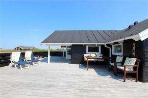a patio with chairs and a table and a roof at 507-Lemvig-Lyngsletten-11 in Lemvig