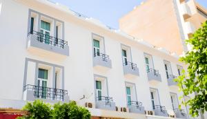 a white building with balconies on it at Hôtel Olympic in Fez