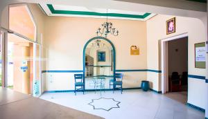 a room with chairs and a table and a mirror at Hôtel Olympic in Fez