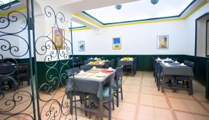 a dining room with tables and chairs and a window at Hôtel Olympic in Fez