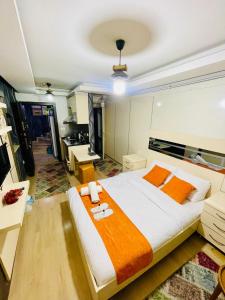 a bedroom with a large bed with orange and white sheets at Taksim Pera Premium Gold Hotel in Istanbul