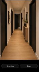 a hallway with black doors and a wooden floor at Appartement walking distant to Tomorrowland in Boom