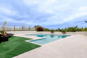 a swimming pool with a green lawn around it at Finca del Carmen by Villas Rivero in Santa Maria de Guia de Gran Canaria