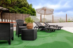 a patio with tables and chairs and an umbrella at Finca del Carmen by Villas Rivero in Santa Maria de Guia de Gran Canaria