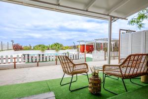 a patio with two chairs and a vase on the grass at Finca del Carmen by Villas Rivero in Santa Maria de Guia de Gran Canaria