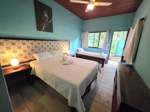 a bedroom with a bed and a chair in a room at Senda Adults Only Hostel in Manuel Antonio