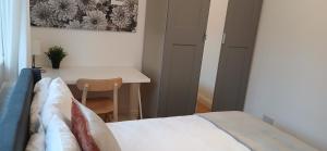 a small bedroom with a bed and a table at Eltham Gem in Eltham