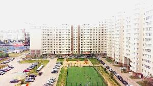 a large building with a parking lot in front of it at Apartment on Infinity Astana in Astana
