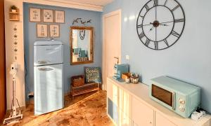 a room with a refrigerator and a clock on the wall at Casa vacanza 'Note di mare' in Torvaianica