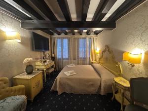 a hotel room with a bed and a desk at Ca' Della Loggia in Venice