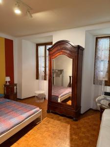 a bedroom with a large mirror and a bed at Casa Fulvia by Lago Maggiore Rentals & Estate in Cannobio