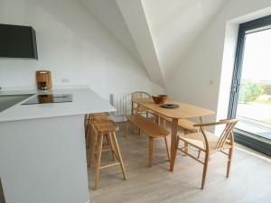 a kitchen and dining room with a table and chairs at Glynllifon 9 in Llanallgo