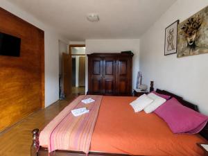 a bedroom with a large bed with an orange blanket at SeaSideApartman3 in Budva