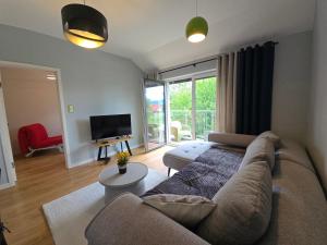 a living room with a couch and a television at Apartamenty Wichrowa in Żywiec