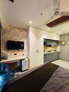 a kitchen with white cabinets and a desk and a tv at Luxury sup nova in New Delhi