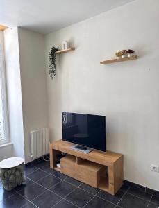 a living room with a flat screen tv on a wooden table at T2 lumineux et tout équipé centre Annonay in Annonay