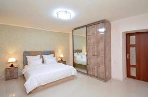 a bedroom with a large white bed and a mirror at Kaskade House in Yerevan +15 photos