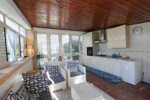 a kitchen with white counters and white cabinets and windows at Villa Incoronata in Torre Specchia Ruggeri
