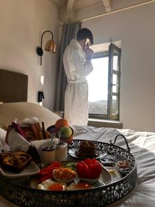 a man talking on a cell phone with a tray of food at Pirrion Villas in Ano Pedina