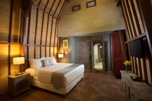 a bedroom with a large bed and a large window at Alindra Villa in Nusa Dua
