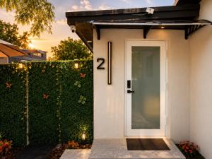 a house with a white door and a hedge at Elegant Retreat Private entrance Modern design in Pembroke Pines +18 photos