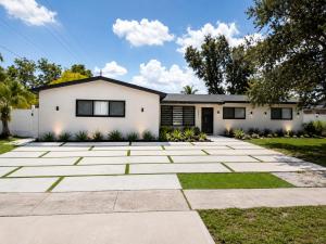 a white house with a driveway at Elegant Retreat Private entrance Modern design in Pembroke Pines