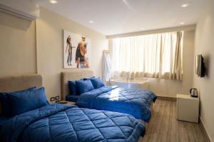 a bedroom with two blue beds and a sink at Explore Pyramids View in Cairo +32 photos