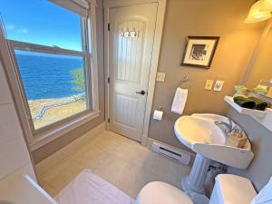 ein Badezimmer mit Waschbecken und Fenster in der Unterkunft Dragon's Lodge in Gabriola
