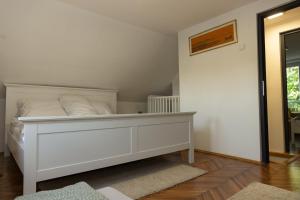 a bedroom with a white bed with white pillows at Vikendica Mir Čortanovci in Čortanovci