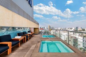 a balcony with chairs and a pool on a building at Hilton Lima Miraflores in Lima