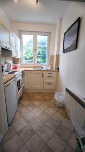 a kitchen with white cabinets and a tile floor at Crandford in Dublin