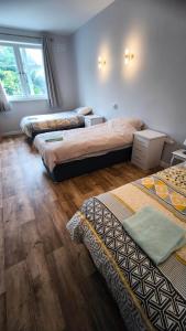 a bedroom with three beds and a window at Crandford in Dublin