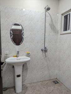 a white bathroom with a sink and a mirror at Shazi Heights in Lahore +10 photos