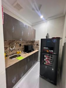 a kitchen with a sink and a refrigerator at Shazi Heights in Lahore