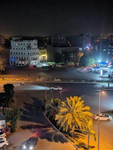 a city street at night with cars and buildings at Shazi Heights in Lahore