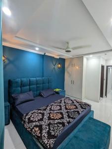 a blue bedroom with a bed with a blue wall at Shazi Heights in Lahore