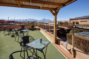 a patio with tables and chairs on a roof at Hoteles Pueblo de Tierra in San Pedro de Atacama