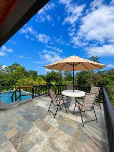 a patio with a table and chairs and an umbrella at Cabaña Lancero in San Pedro