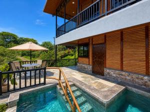 a house with a swimming pool and an umbrella at Cabaña Lancero in San Pedro
