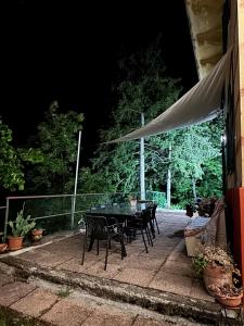 a table and chairs on a patio at night at Casa Bertulla in Cabella Ligure