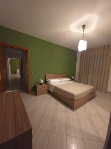 a bedroom with a bed and a green wall at Casa Cirillo in Marigliano