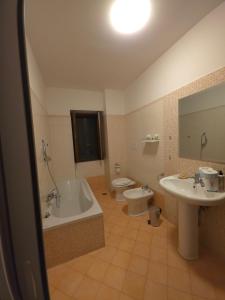 a bathroom with a tub and a toilet and a sink at Casa Cirillo in Marigliano