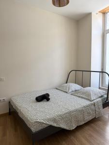 a bedroom with a bed with a hat on it at T2 lumineux et tout équipé centre Annonay in Annonay