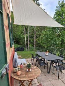 a patio with a table and chairs and an umbrella at Casa Bertulla in Cabella Ligure +11 photos