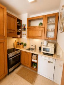 a kitchen with wooden cabinets and a sink and a microwave at SeaSideApartman3 in Budva