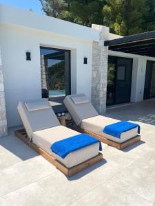 two beds sitting on a patio in front of a house at Villa Hillside Skiathos in Skiathos