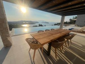 a wooden table and chairs on a patio at Villa Hillside Skiathos in Skiathos