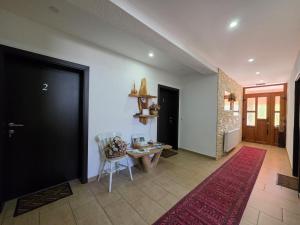 a hallway with a black door and a table and chairs at Guest House Bunčić Rooms in Slunj